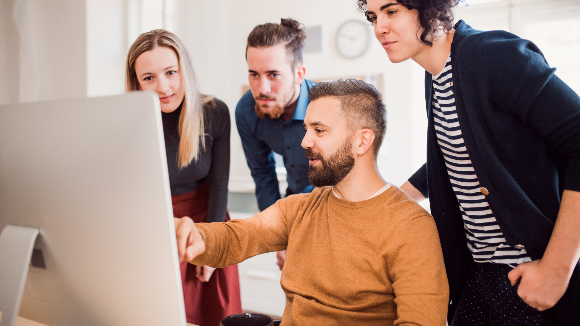 Small agency team reviewing software together on a laptop